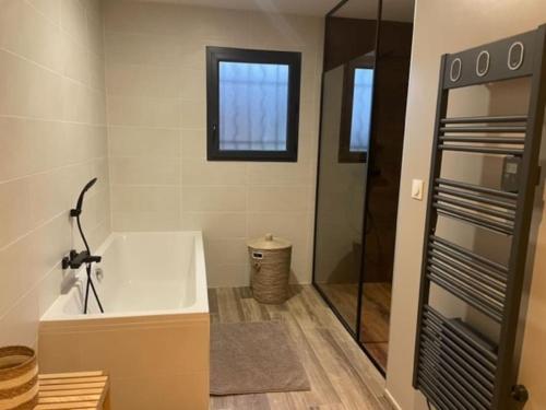 a bathroom with a bath tub and a shower at Cassie Home in Saint-Jean-en-Royans