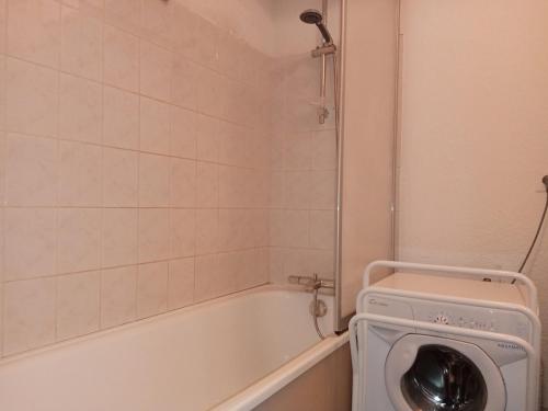 une salle de bain avec baignoire et machine à laver dans l'établissement Appartement cosy avec balcon, 2 chambres, parking et wifi à Châtel - FR-1-198-162, à Châtel
