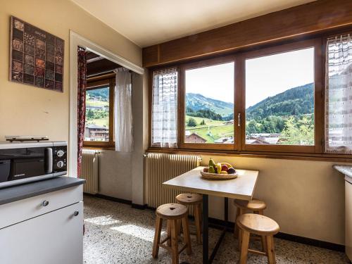 une cuisine avec une table avec un bol de fruits dessus dans l'établissement Appartement 2 chambres centre village - Proche pistes, cheminée, animaux admis - FR-1-437-41, à La Clusaz