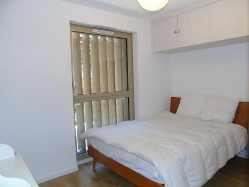 een witte slaapkamer met een bed en een raam bij Appartement Châtel, 3 pièces, 4 personnes - FR-1-198-164 in Châtel