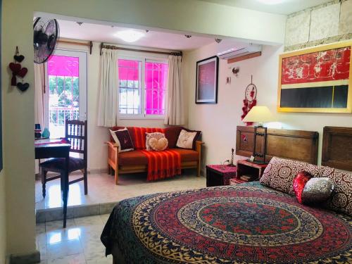 a bedroom with a bed and a living room at Corazón by Majikal B&B in Mérida