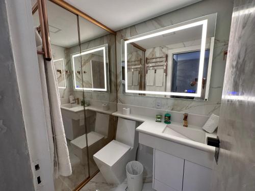 y baño con lavabo, aseo y espejo. en Flat 1092 Jardins, en São Paulo