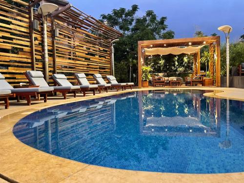 Heaven Prestige Hotel في جونية: مسبح مع كراسي جلوس بجانب فناء