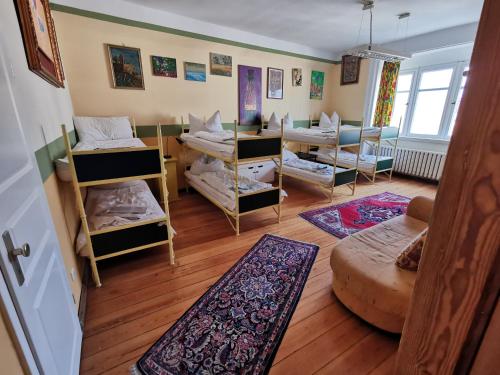 um quarto com beliches e uma sala de estar em Hummel Hostel - Historische Stadtvilla mit Garten em Veimar