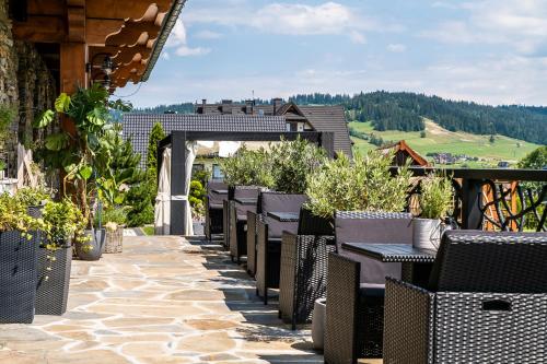 a row of tables and chairs on a patio at Silverton -sauna,jacuzzi,mini siłownia,bar sezonowy, przyjazny rodzinom in Białka Tatrzanska