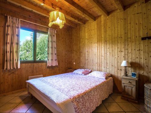 une chambre avec un lit dans une pièce en bois dans l'établissement Chalet 10 pers à La Clusaz - 5 ch - Calme - Cheminée - Animaux admis - Parking - FR-1-437-73, à La Clusaz