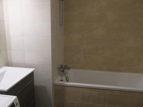 een badkamer met een bad en een wastafel bij Appartement Châtel, 4 pièces, 6 personnes - FR-1-198-195 in Châtel