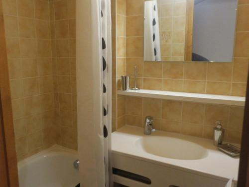 une salle de bain avec un lavabo, une baignoire et un miroir dans l'établissement Petit appartement cocooning - 5 Personnes - FR-1-198-196, à Châtel