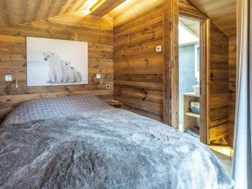 une chambre avec un lit dans une pièce aux murs en bois dans l'établissement Chalet Chaleureux - 1 Ch - 4 Pers - Terrasse - Parking - FR-1-437-75, à La Clusaz