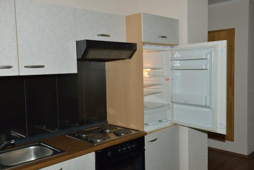 a kitchen with an empty refrigerator and a sink at Land- und Golfhotel Alte Fliegerschule in Eisenach