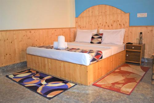1 cama con cabecero de madera en una habitación en Spire View en Manāli