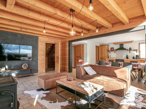un salon avec un canapé et une table dans l'établissement Chalet 4 Étoiles 13 Pers. à La Clusaz - Grande Terrasse, Garage, WIFI, Arrêt Skibus à Proximité - FR-1-437-81, à La Clusaz