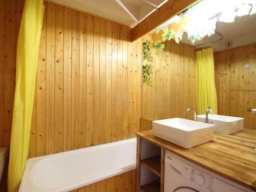 une salle de bain avec une baignoire et un lavabo et une baignoire dans l'établissement Studio avec Balcon et Ascenseur - 200m du Centre - FR-1-608-137, à Le Mont-Dore