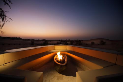 a fire pit with a view of the desert at sunset at Telal Resort Al Ain in Al Ain