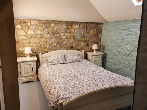 ein Schlafzimmer mit einem Bett und zwei Nachttischen mit Lampen in der Unterkunft Au pti fayt in Barbençon