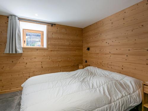 拉克呂薩的住宿－Appartement La Clusaz, 2 pièces, 4 personnes - FR-1-437-89，卧室设有木墙和白色的床。