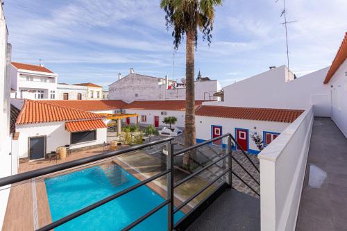einen Blick vom Balkon eines Hauses mit Pool in der Unterkunft Luxury Palm Suites in Reguengos de Monsaraz