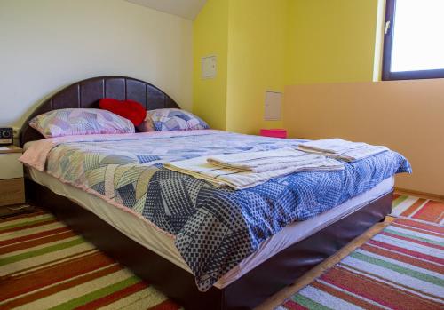 een slaapkamer met een bed met een blauw dekbed bij Apartmani Rocen in Žabljak