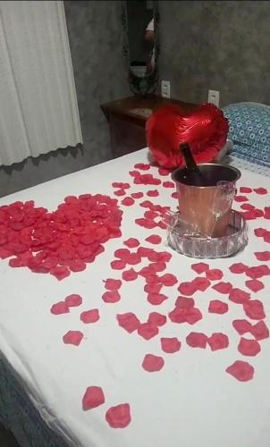 a bunch of red roses on a bed with a table at VG Sun Cumbuco Sea Breeze Vista Mar in Cumbuco