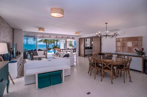 a kitchen and living room with a table and chairs at Casa Margot - Casas de Luxo Pé na Areia in Juquei