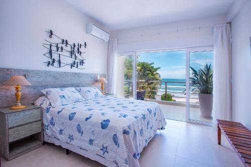 Schlafzimmer mit einem Bett und Meerblick in der Unterkunft Casa Margot - Casas de Luxo Pé na Areia in Juquei