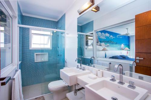 uma casa de banho com um lavatório, um WC e um espelho. em Casa Margot - Casas de Luxo Pé na Areia em Juqueí