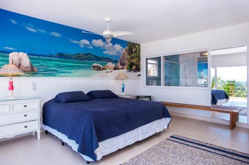 a bedroom with a bed and a large painting on the wall at Casa Margot - Casas de Luxo Pé na Areia in Juquei