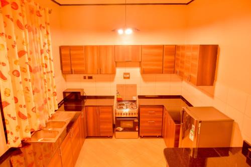 a small kitchen with wooden cabinets and a stove at Hilltop apartments in Bwebajja