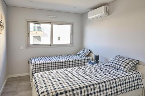 1 dormitorio con 2 camas y ventana en Nice apartment near the beach - Monte Gordo, en Monte Gordo