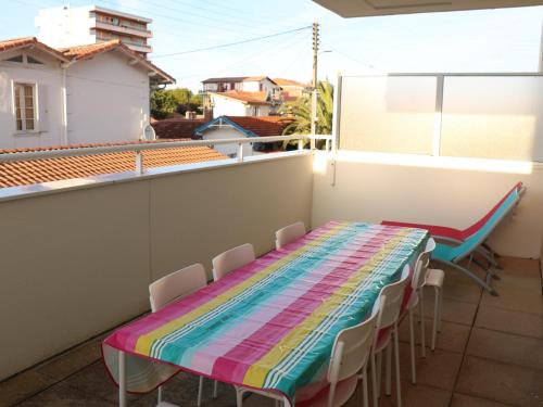 d'une table et de chaises colorées sur un balcon. dans l'établissement Duplex T4 à Arcachon: Terrasse, WiFi, Parking, à 150m de la Plage - FR-1-374-22, à Arcachon