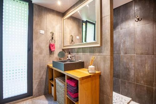 a bathroom with a sink and a mirror at Les Trigones du Causse -Maison atypique avec Piscine Privée in Saint-Martin-Labouval