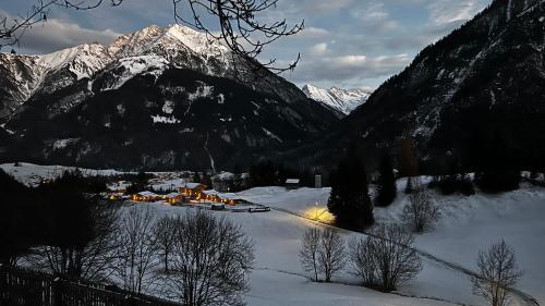 a group of buildings in the snow in front of a mountain at Alpfee Lechtal in Bach