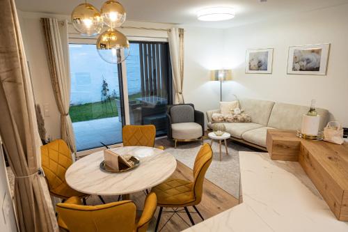 a living room with a table and a couch at Ferienwohnung Deluxe Sattendorf in Sattendorf