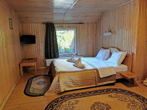 - une chambre avec un lit dans une pièce en bois dans l'établissement Pensiunea Valea Cetatii, à Râșnov