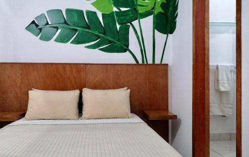 a bedroom with a bed with a large plant above it at Piccolo Bed & Breakfast in Tarapoto