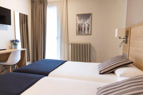 um quarto de hotel com uma cama e uma secretária em Hotel Terminus em Puigcerdà