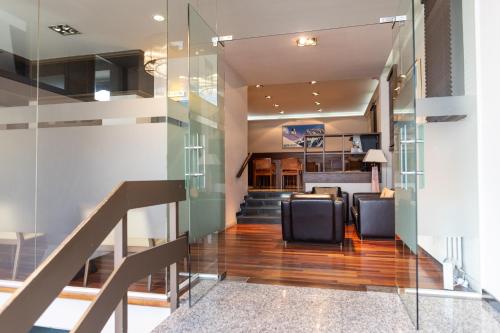 een lobby met stoelen en een trap met glazen wanden bij Hotel Terminus in Puigcerdà