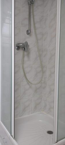 een douche met een slang in de badkamer bij Chambres au Village in Saint-Mʼhervé