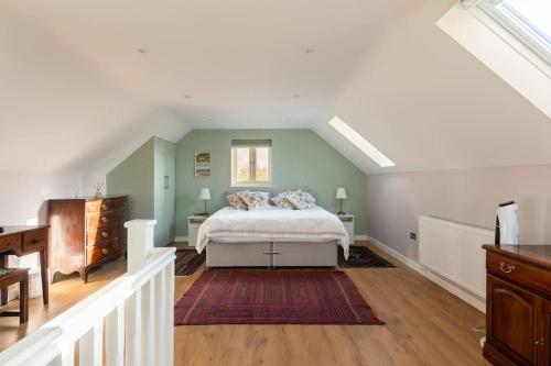 ein Schlafzimmer mit einem großen Bett im Dachgeschoss in der Unterkunft Delightful Country Cottage in a lovely rural area in Ludlow