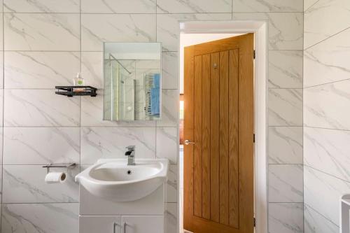 ein weißes Badezimmer mit einem Waschbecken und einem Spiegel in der Unterkunft Delightful Country Cottage in a lovely rural area in Ludlow
