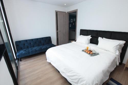 カサブランカにあるJoumaya Luxury Gauthierのベッドルーム(白い大型ベッド1台、青いソファ付)