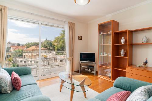 a living room with a couch and a large window at Ilhéus III by An Island Apart in Funchal
