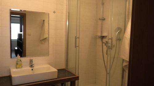 a bathroom with a sink and a shower with a mirror at Studio with a view of the center of Bratislava in Bratislava