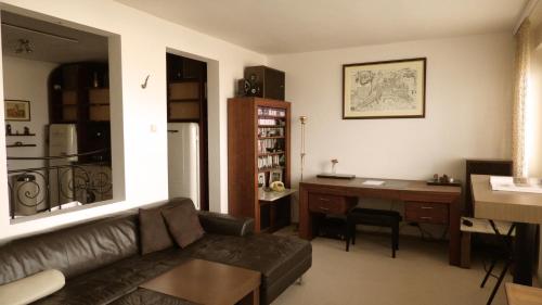 a living room with a couch and a desk at Studio with a view of the center of Bratislava in Bratislava