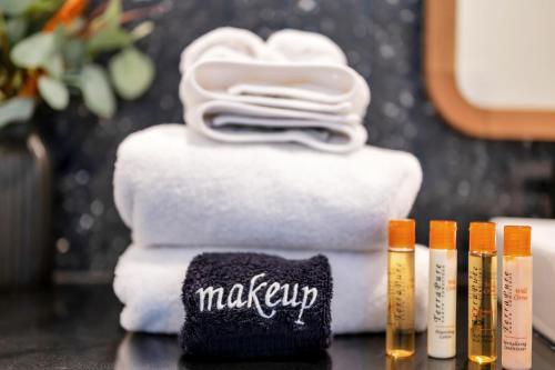 a pile of towels and a towel with the word makeup on it at Upscale Rainey St Condo Homes - Peloton, gym, rooftop pool, wifi included in Austin