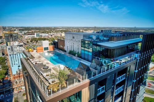 una vista aérea de un edificio con piscina en Upscale Rainey St Condo Homes - Peloton, gym, rooftop pool, wifi included, en Austin