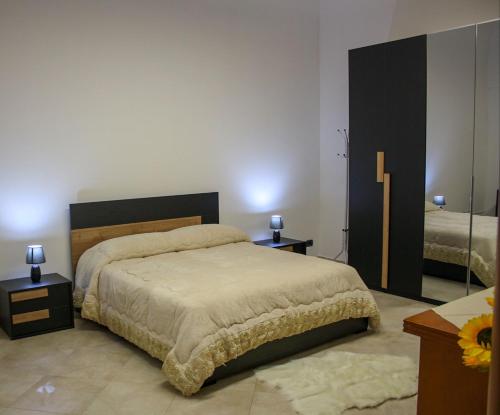 1 Schlafzimmer mit einem Bett, 2 Tischen und einem Spiegel in der Unterkunft Stupor Mundi in Bitritto