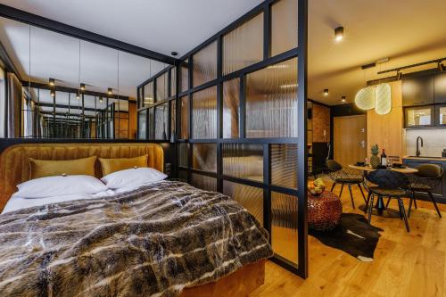 a bedroom with a large bed and a dining room at APARTAMENT CHICAGO - stylowy apartament o bardzo wysokim standardzie w centrum miasta, z prywatnym zadaszonym parkingiem - IZBY PODHALAŃSKIE in Nowy Targ