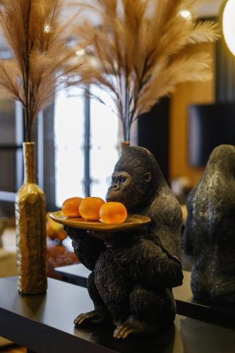a statue of a gorilla holding a plate of oranges at APARTAMENT CHICAGO - stylowy apartament z KLIMATYZACJĄ o bardzo wysokim standardzie w centrum miasta, z prywatnym zadaszonym parkingiem - IZBY PODHALAŃSKIE in Nowy Targ
