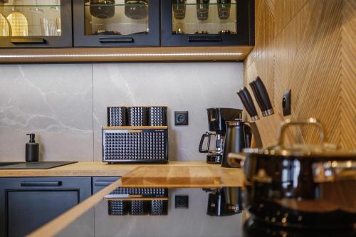 a kitchen with blue cabinets and a counter top at APARTAMENT CHICAGO - stylowy apartament z KLIMATYZACJĄ o bardzo wysokim standardzie w centrum miasta, z prywatnym zadaszonym parkingiem - IZBY PODHALAŃSKIE in Nowy Targ